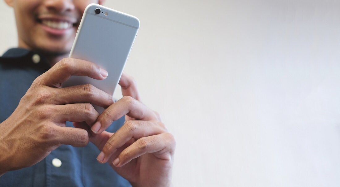 Young adult holding an iPhone.