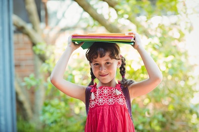 Girl holding books on top of her head.