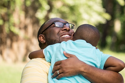 Dad hugging his son.