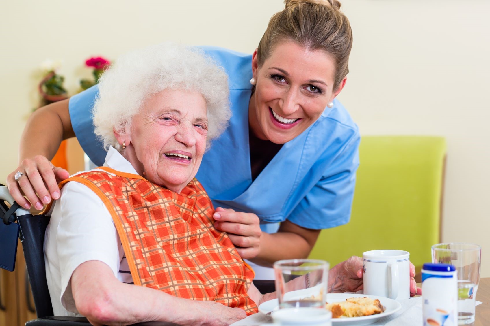 Two individuals smiling in front on a table with food on it