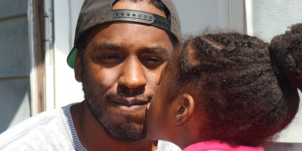 Young girl kissing father on cheek