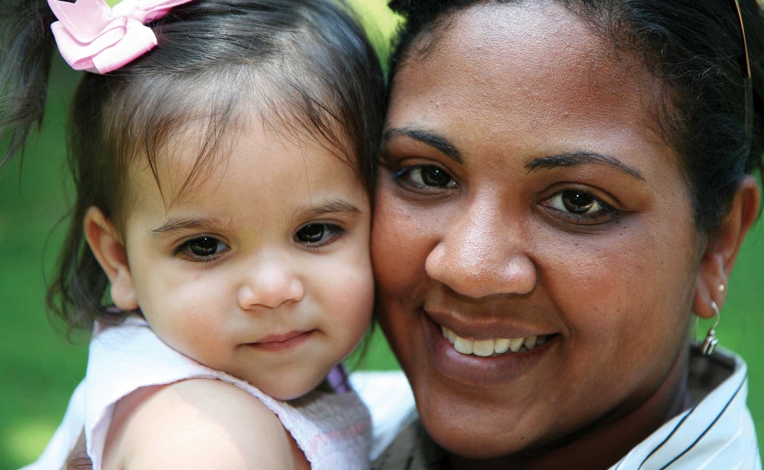 Woman and toddler smiling.