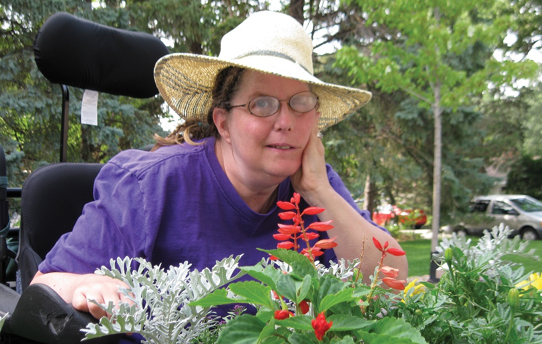 Woman sitting by flowers.