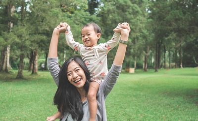 Mother carrying child on her shoulders.