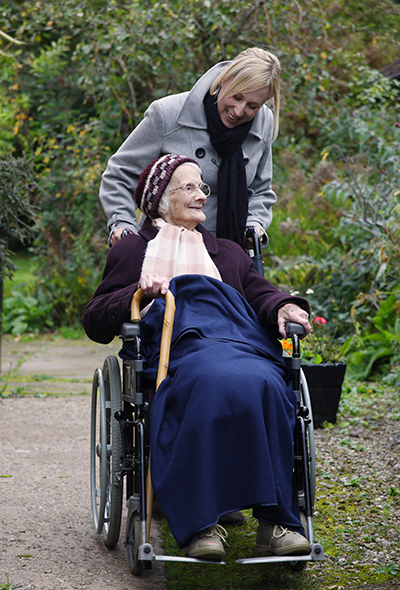 Caregiver and elderly women in a wheelchair outside