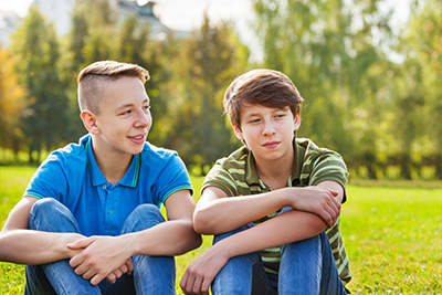 Two boys sitting on the grass