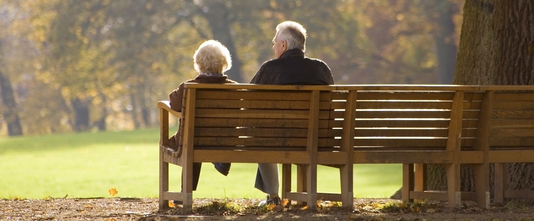 elderly couple sitting on bench