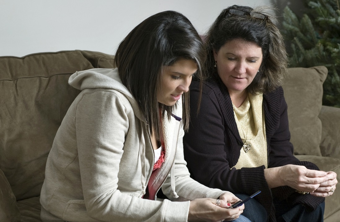 woman and teenager sitting on couch