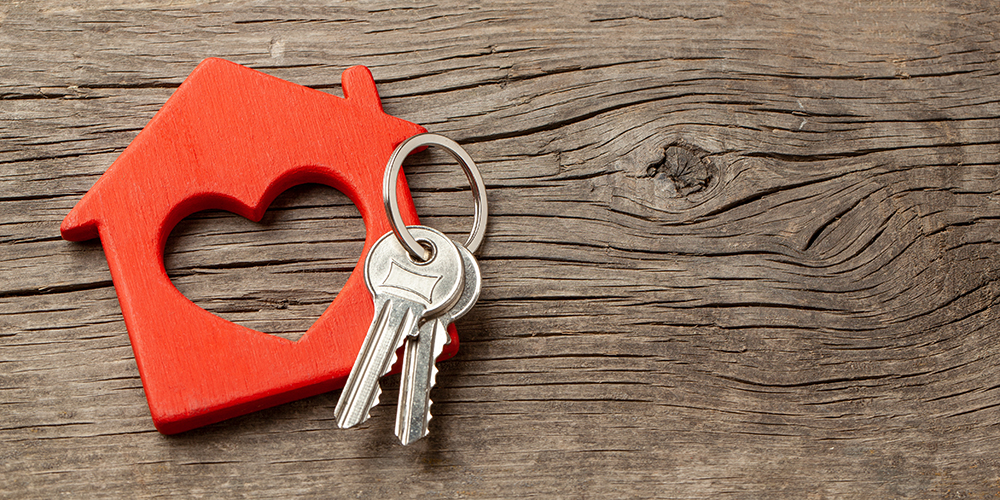 Keys on a table next to a home heart symbol