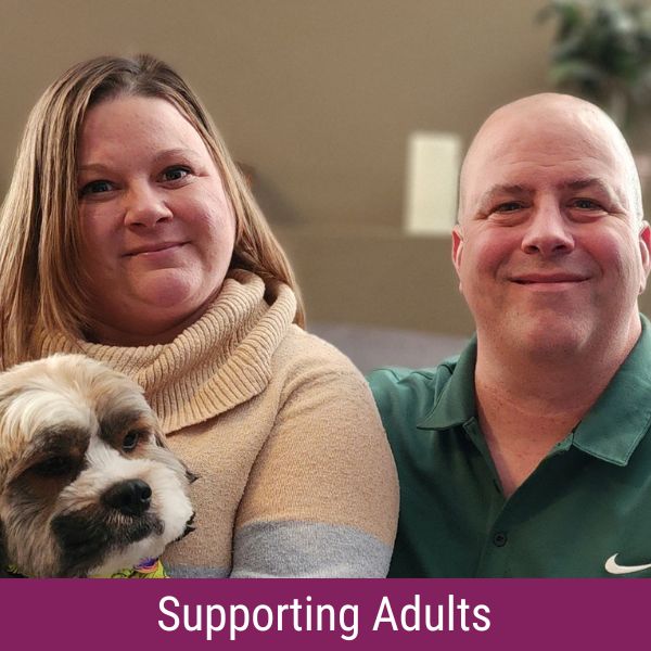 Jeremy with his partner and dog, with banner reading "supporting adults".