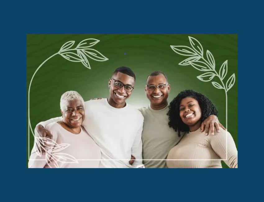 Four black individuals, two younger and two older, with their arms around each other and smiling for the camera.