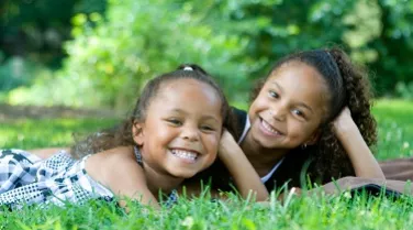 two girls sitting on grass