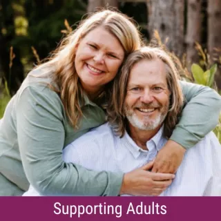 Rhonda and Roger Lemmon with banner reading "Supporting Adults"